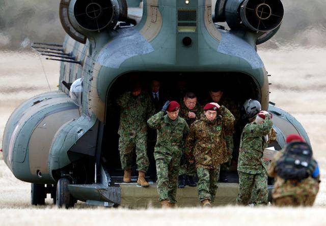 고이즈미 신지로(앞줄 가운데) 일본 방위장관이 11일 도쿄 인근 후나바시시 자위대 나라시노캠프에서 열린 육상자위대 제1공수여단 낙하산 훈련에 참석하기 전 헬기에서 내려 걸어가고 있다. 후나바시=EPA 연합뉴스
