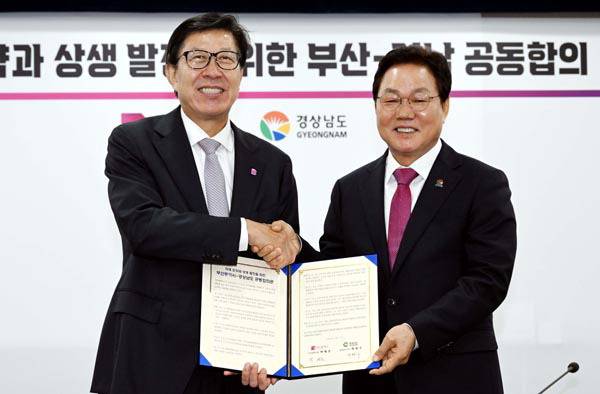 박형준 부산시장과 박완수 경남도지사가 2024년 6월 17일 부산시청에서 행정통합을 비롯한 지역 공동 현안과 관련한 공동합의문에 서명하고 나서 악수하는 모습. 국제신문 DB