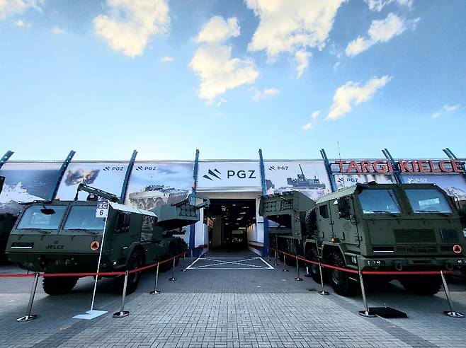 The Polish Chunmoo multiple launch rocket system, right, and the U.S.-made High Mobility Artillery Rocket System by Lockheed Martin are seen on display at the entrance to the MSPO defense exhibition in Kielce, Poland, in October 2023 in this photo provided by Hanwha Aerospace [HANWHA AEROSPACE]