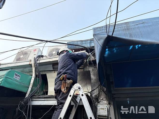 [서울=뉴시스]신유림 기자=지난 19일 오후 서울 중구 인현시장에 노후 전선에서 스파크가 튀어 한국전력공사 직원이 수리하고 있다. 2026.01.23. spicy@newsis.com