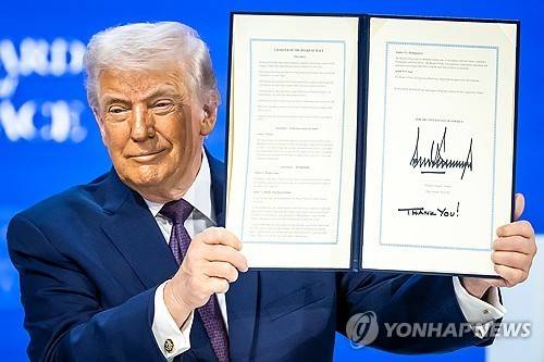 평화위원회 헌장 들고 있는 트럼프 대통령 [AP 연합뉴스. 재판매 및 DB 금지]