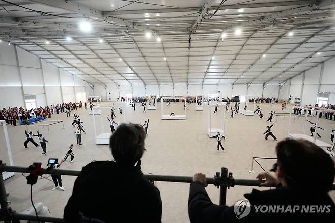 이탈리아 밀라노에 설치된 대형 텐트에서 올림픽 개회식 리허설을 펼치는 자원봉사자들 [AP=연합뉴스]