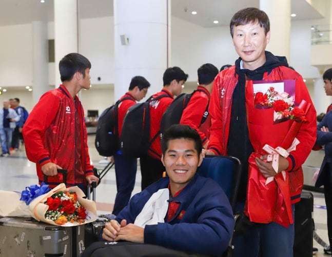 제자의 휠체어를 끄는 김상식 감독(오른쪽)(베트남넷 제공)