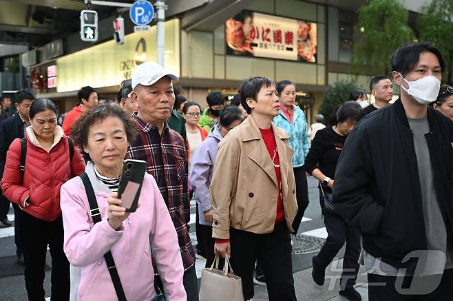 일본 도쿄 긴자의 쇼핑가에서 17일(현지시간) 중국인 관광객이 도로를 건너고 있다. 2025.11.17 ⓒ AFP=뉴스1 ⓒ News1 김경민 기자