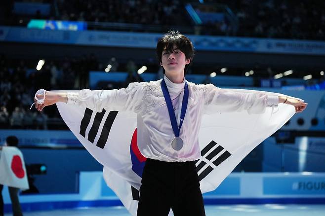 ‘피겨 프린스’ 차준환이 25일 중국 베이징에서 끝난 국제빙상경기연맹(ISU) 피겨 4대륙선수권대회 남자 싱글에서 은메달을 차지한 뒤 몸에 태극기를 두르고 팬들에게 인사를 하고 있다. 베이징=AP 뉴시스