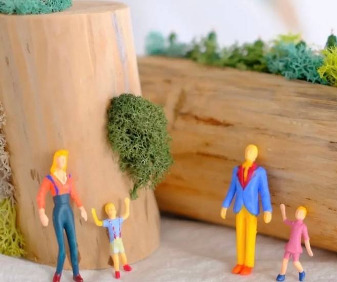 삼나무 단면 위에 놓인 작은 인물들. 자원과 사람, 기억을 연결하는 리본아트 작업의 한 장면이다. (한국리본ReBorn협회)