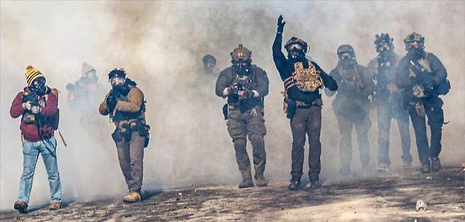 < 연방요원·시위대 충돌 격화…거리 곳곳에 최루탄 > 24일(현지시간) 미국 미네소타주 미니애폴리스에서 민간인이 이민 단속 요원 총에 맞아 숨진 후 사건 현장 근처에 모인 시위대를 향해 연방 요원이 최루탄을 던지고 있다. 이번 사건은 미니애폴리스에서 지난 7일 이민세관단속국(ICE) 총격으로 미국 시민 한 명이 사망한 지 3주도 안 돼 발생했다.  AFP연합뉴스