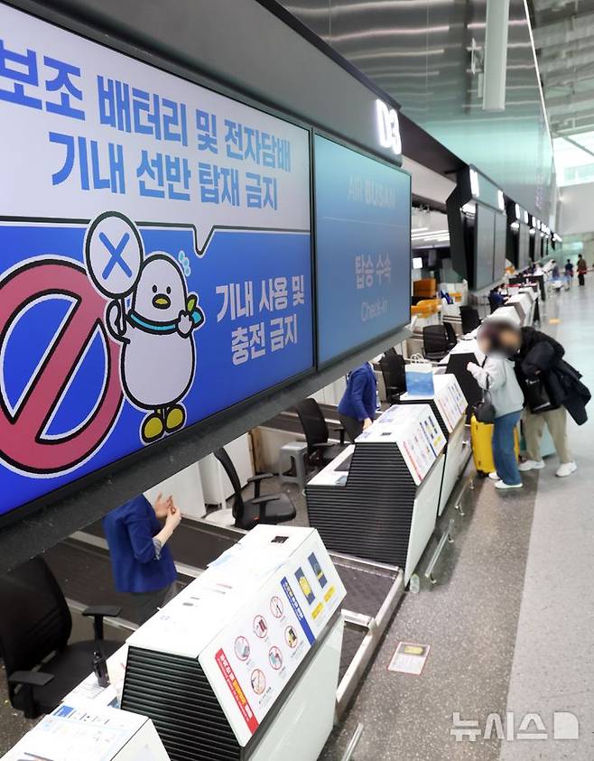 [부산=뉴시스] 하경민 기자 = 대한항공과 아시아나항공, 진에어, 에어부산, 에어서울 등이 기내에서 보조배터리 사용 전면 금지를 시작한 26일 부산 강서구 김해국제공항 국제선 에어부산 탑승수속대에서 보조배터리 기내 사용 금지를 안내하는 문구가 나오고 있다. 2026.01.26. yulnetphoto@newsis.com