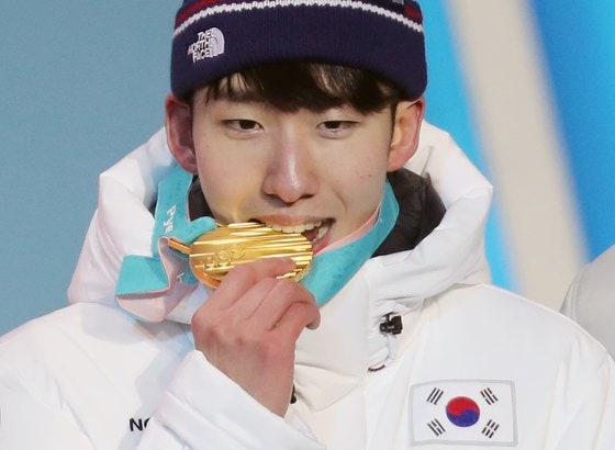 2018 평창 동계올림픽 쇼트트랙 남자 1500m 금메달을 딴 임효준이 시상대에서 금메달을 깨물고 있다. 연합뉴스