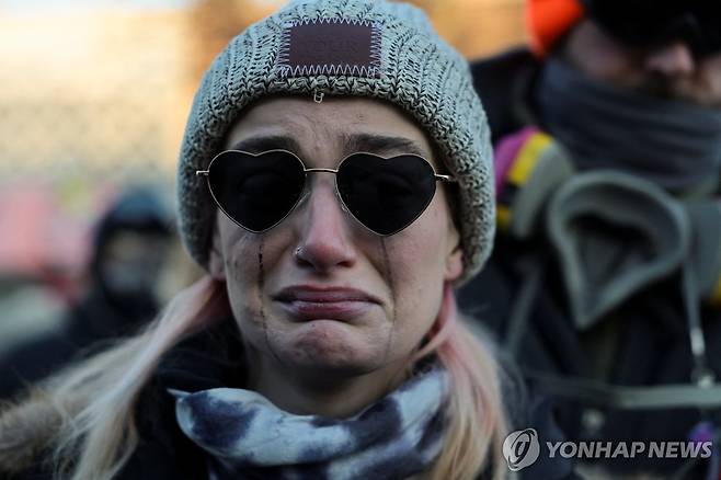 24일(현지시간) 연방 요원에게 사살된 알렉스 프레티 추모하는 여성 [로이터=연합뉴스. 재판매 및 DB 금지]