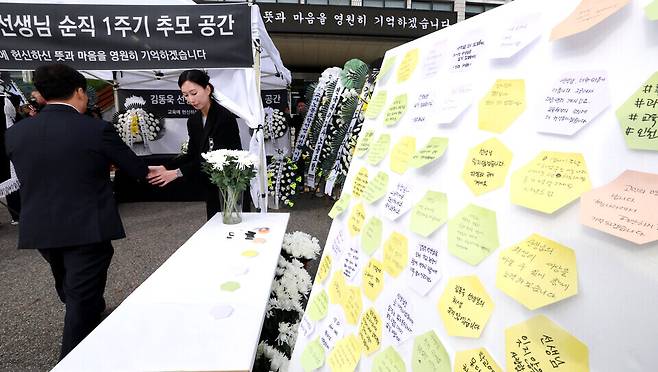 ▲&nbsp;지난해 10월21일 인천시교육청 앞에서 학산초 특수교사 고 김동욱 교사의 순직 1주기 추모식이 열린 가운데 참석자들이 헌화를 하고 있는 모습. /인천일보DB