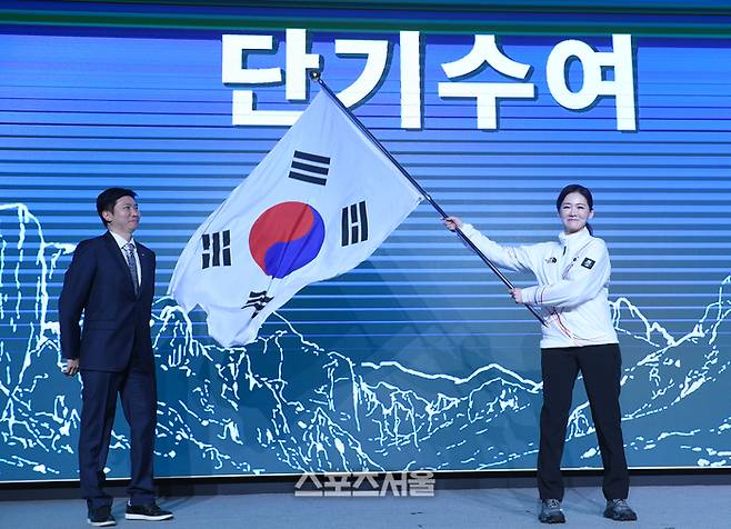 이수경 선수단장이 22일 서울 송파구 올림픽파크텔에서 열린 2026 밀라노코르티나 동계올림픽 대한민국 선수단 결단식에서 유승민 대한체육회장에 받은 단기를 흔들고 있다.  잠실 | 최승섭기자 thunder@sportsseoul.com