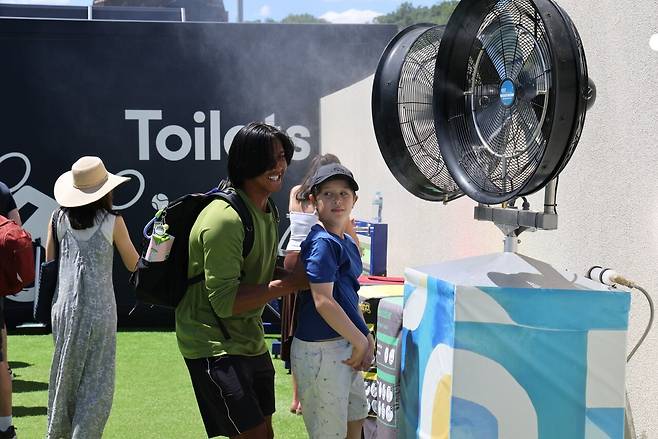 2026 호주오픈 대회장 곳곳에 설치된 쿨링팬 앞에서 더위를 식히고 있는 아이