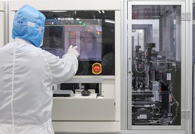 사람이 일일이 확인하던 걸 AI가 순식간에 - 지난 7일 경기도 시흥시 대덕전자의 반도체 공장 클린룸에서 한 직원이 '불량 검사 AI' 시스템을 살펴보고 있다. 이 AI는 반도체 기판(PCB) 132개를 한꺼번에 스캔해 양품은 초록색, 스크래치가 난 불량품은 붉은색으로 표시한다. 기존에는 사람이 기판을 20~30배 확대해 육안으로 일일이 확인했지만, AI는 30초 만에 모든 검사를 마친다. /박성원 기자