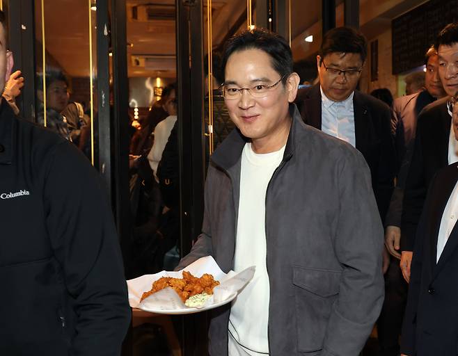 이재용 삼성전자 회장이 2025년 10월 30일 서울 강남구 깐부치킨 삼성점에서 젠슨황 엔비디아 최고경영자와 '치맥' 회동 중 시민들에게 치킨을 나눠주고 있다./ 뉴스1