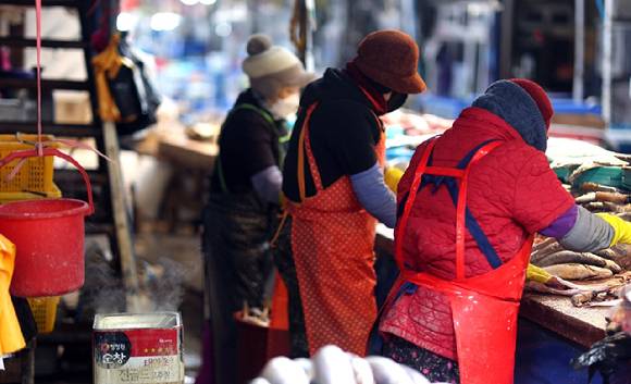 추위가 이어진 가운데 경남 창원시 마산합포구 마산어시장에서 상인들이 피어오르는 김 곁에서 분주하게 생선을 손질하고 있다. [사진=연합뉴스]