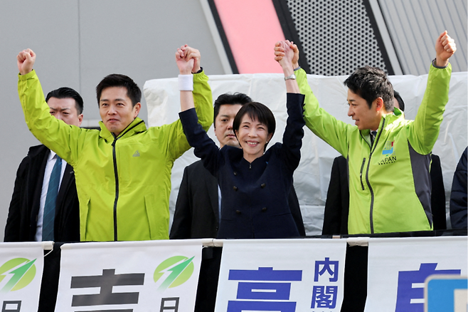 27일 다카이치 사나에 일본 총리(가운데)가 연립여당인 일본유신회의 요시무라 히로후미(왼쪽), 후지타 후미타케 공동대표와 함께 중의원 첫 선거유세가 진행된 도쿄 지요다구 아키하바라역에서 포즈를 취하고 있다. [로이터 연합뉴스]