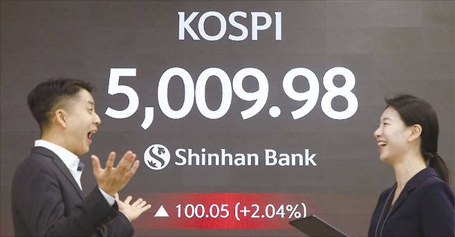 코스피가 사상 처음 장중 5000선을 넘어선 가운데, 지난 1월 22일 오전 서울 중구 신한은행 본점 딜링룸에서 직원들이 기뻐하고 있다. (신한은행 제공)