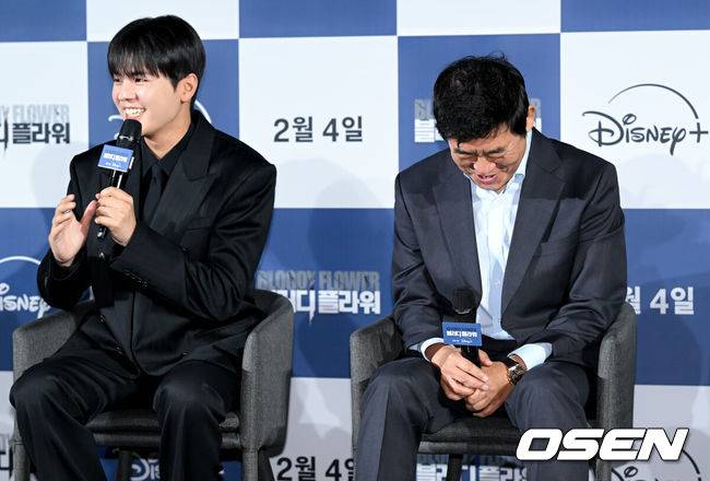 [OSEN=조은정 기자] 디즈니+ '블러디 플라워' 제작발표회가 27일 서울 용산구 CGV용산아이파크몰에서 열렸다.블러디 플라워‘는 모든 불치병을 치료할 수 있는 능력을 가진 연쇄살인범을 둘러싼 사람들의 이야기를 그린 미스터리 스릴러다.&nbsp;배우 성동일이 려운의 인터뷰 답변에 미소를 짓고 있다. 2026.01.27 /cej@osen.co.kr