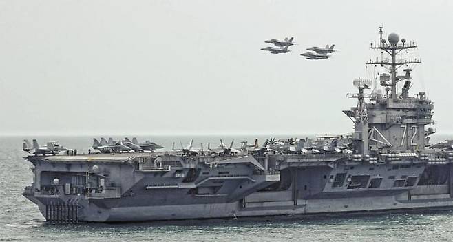 미군의 니미츠급 항공모함 에이브러햄 링컨호가 항해하는 모습. 링컨호에 소속된 전투기 ‘FA-18F 수퍼 호넷’이 항모와 함께 비행하고 있다. 존 볼턴 미 백악관 국가안보회의(NSC) 보좌관은 5일(현지 시각) 에이브러햄 링컨 항모 전단과 폭격기들을 중동 지역에 배치하고 있다고 밝히며 “이란 정권을 향해 미국과 동맹국에 대한 어떠한 공격이라도 가차 없는 대응에 맞닥뜨리게 될 것이라는 메시지를 보내려는 조치”라고 말했다./EPA 연합뉴스