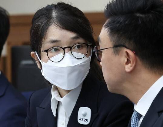 김건희 여사가 지난해 9월24일 오후 서울 서초구 서울중앙지법에서 열린 첫 재판에 출석해 최지우 변호사와 이야기를 나누고 있다. 김 여사는 왼쪽 가슴에 ‘수용번호 4398’이 적힌 배지를 달았다. 연합뉴스