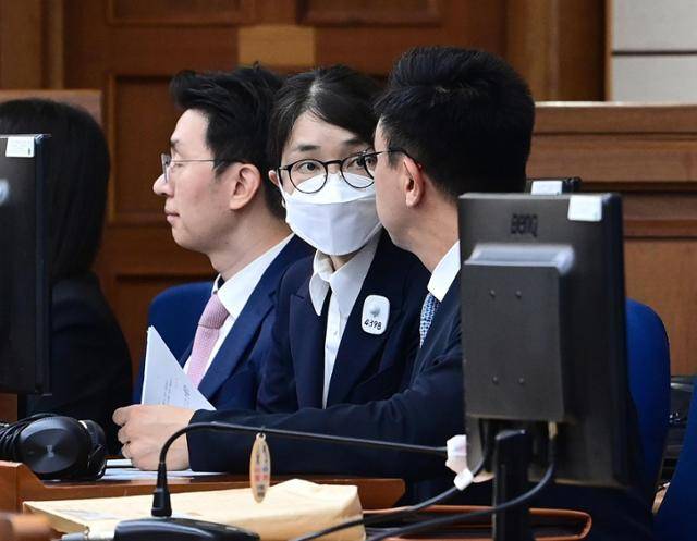 김건희(가운데) 여사가 지난해 9월 24일 서울 서초구 서울중앙지법에서 열린 첫 공판 도중 변호인과 대화하고 있다. 사진공동취재단