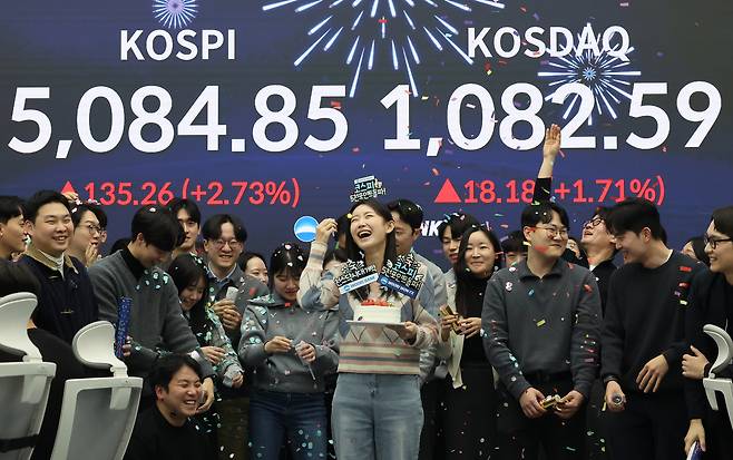 27일 서울 중구 우리은행 딜링룸에서 관계자들이 종가 기준 코스피 5000 돌파 기념 세리머니를 하고 있다.  [연합]