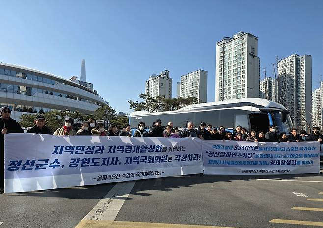 정선 숙암리 주민들이 27일 올림픽파크텔 앞에서 포럼 참석에 앞서 정선군수, 강원도지사, 지역 국회의원을 비판하며 스키장 존속과 개발을 요구하는 플래카드를 들고 있다.