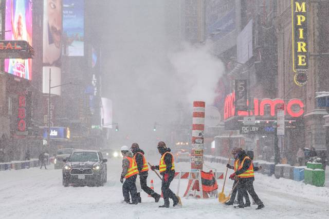 미국 뉴욕 맨해튼 타임스스퀘어에서 도로 제설 작업자들이 거센 눈보라를 헤치고 길을 건너가고 있습니다. 로이터 연합뉴스