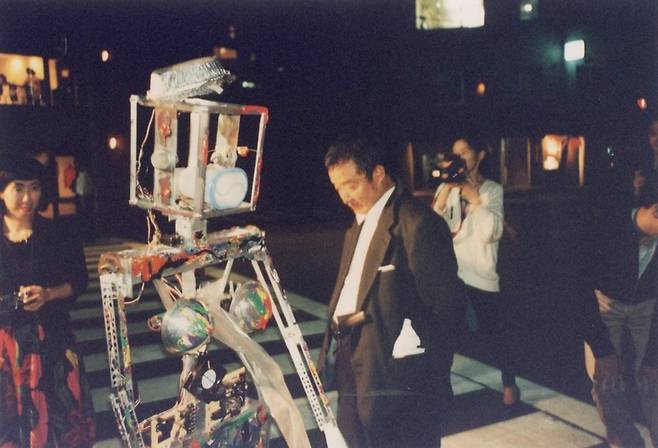 Artist Nam June Paik, center, with his ″Robot K-456″ (1964) piece in Tokyo in this undated photo [NAM JUNE PAIK ART CENTER ARCHIVE]