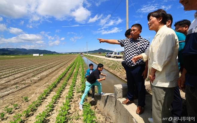 [세종=뉴시스] 강종민 기자 = 송미령 농림축산식품부 장관이 29일 전북 부안군 행안면의 논콩 전문생산단지를 살펴보며 농업인의 의견을 경청하고 있다.  논콩은 양곡관리법 개정의 핵심방향인 ‘논 타작물 재배 확대를 통한 사전적 수급관리 강화’와 관련된 대표적인 품목이다.  (사진=농식품부 제공) 2025.06.30. photo@newsis.com *재판매 및 DB 금지 /사진=강종민