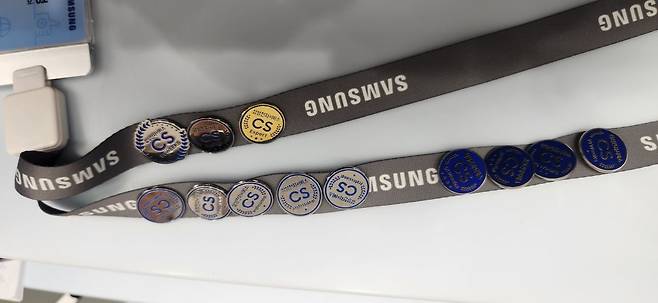 최씨의 사원증에 달린 CS 관련 배지 12개. 손에 쥐자 제법 묵직한 무게가 전해졌다. 백재연 기자