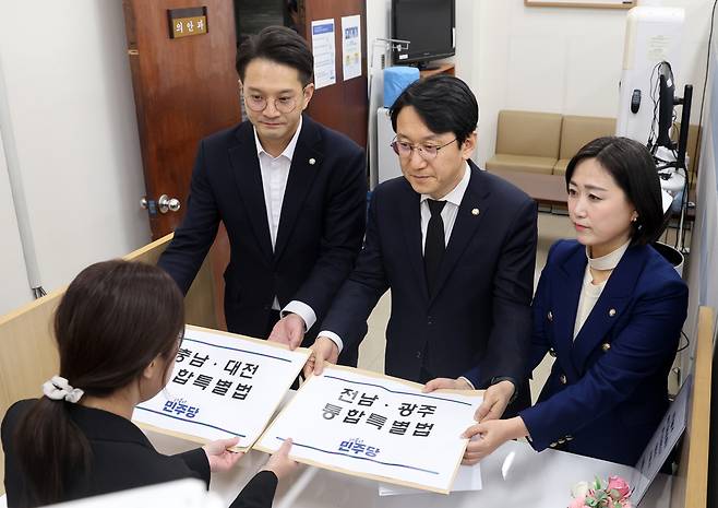 더불어민주당 천준호 원내운영수석부대표와 전용기 원내소통수석부대표가 30일 국회 의안과에 충남대전통합특별법안과 전남광주통합특별법안을 제출하고 있다./ 연합뉴스