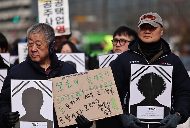 ‘동자동 쪽방 공공주택 촉구 결의대회’ 참가자들이 희생자들의 영정과 손팻말을 들고 있다.