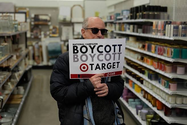 지난달 31일(현지시간) 미네아폴리스의 타깃 매장에서 한 시민이 타깃에 대한 불매운동 피켓을 들고 있다. 타깃과 홈디포 등 일부 기업들은 이민당국의 활동을 지원한 기업으로 알려지면서 시민들의 반발을 사고 있다. AP=연합뉴스