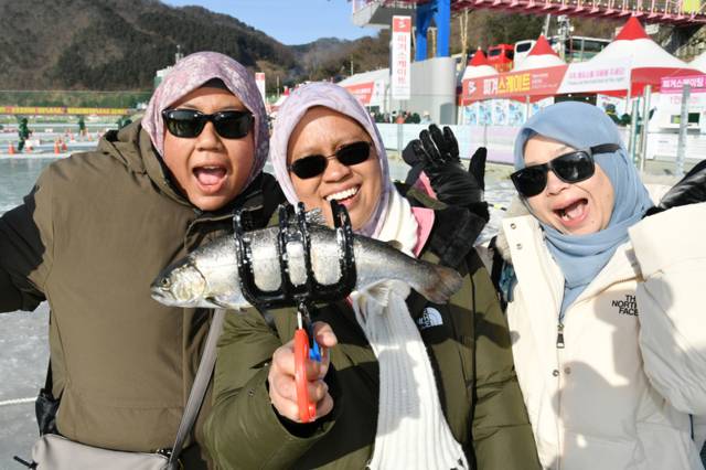 ▲ 2026 화천산천어축제 폐막일인 1일, 축제장을 방문한 외국인 단체 관광객, 자유 여행가들이 산천어 얼음낚시 재미에 흠뻑 빠져 있다.
