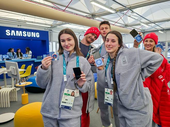 폴란드 선수들이 코르티나 올림픽 선수촌 내 삼성 체험관을 방문해 갤럭시Z플립7 올림픽 에디션을 선보이고 있다. 사진=삼성전자
