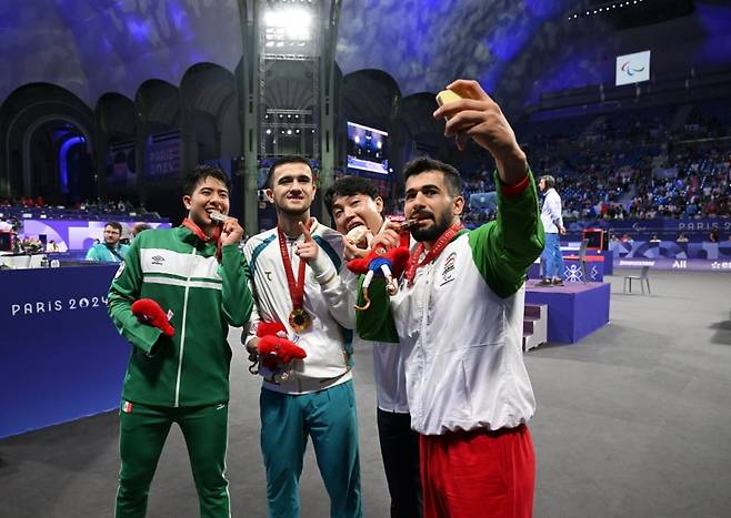 2024년 8월31일(현지시간) 프랑스 파리 그랑팔레에서 열린 2024 파리 패럴림픽 장애인 남자 태권도 공동 취재구역에서 은메달 루이스 나헤라(멕시코·왼쪽부터), 금메달 아사드벡 토슈테미로프(우즈베키스탄), 동메달 주정훈(대한민국), 알리레자 바크흐트(이란) 선수가 갤럭시Z플립6 올림픽 에디션으로 빅토리 셀피를 찍고 있다. 사진=삼성전자