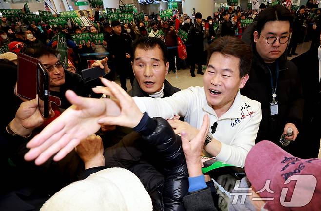 전한길 전 한국사 강사가 3일 인천국제공항 제2여객터미널로 귀국해 지지자들을 향해 손을 뻗고 있다. 2026.2.3/뉴스1 ⓒ News1 이호윤 기자