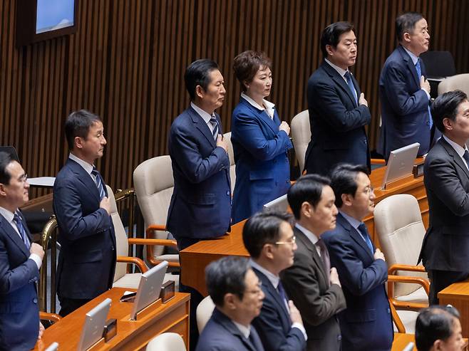 더불어민주당 정청래 대표(뒷줄 왼쪽 세 번째)와 한병도 원내대표(뒷줄 왼쪽 두 번째), 이언주 최고위원(뒷줄 왼쪽 네 번째)을 비롯한 민주당 지도부 들이 2일 국회에서 열린 2월 임시회 개회식에 참석해 국기에 경례하고 있다. /연합뉴스