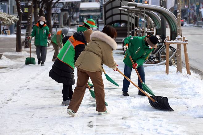 눈이 내려 쌓인 2일 오전 대전 서구 둔산동에서 서구청 관계자들이 제설작업을 하고 있다.[연합]