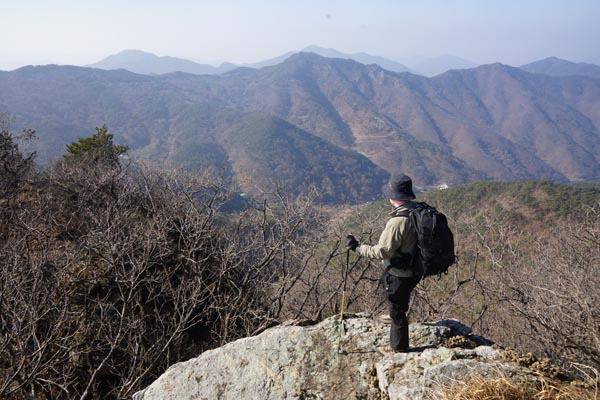 조망이 잘 열리지 않는 경남 양산시 원동면 매봉 산행에서 시원하게 열리는 전망대는 770봉을 내려서면서 만난다. 취재팀이 로프를 잡고 올라가 바위 전망대에서 바라보는 서쪽으로 정면에 금오산에서 가래봉을 잇는 능선 뒤로 밀양 땅의 구천산 만어산 천지봉이 보인다. 발 아래 깊은 골짜기는 밀양시 단장면 국전리이다.
