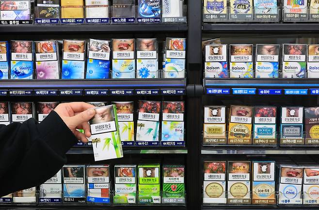 서울 한 편의점에서 점원이 진열된 담배를 들어 보이는 모습 [연합]