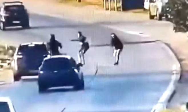 도로에 뛰어든 2인조 권총강도. CCTV 캡처