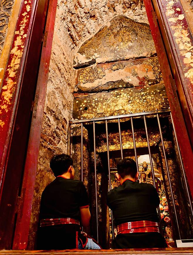 푸 타이 전통 복장을 입은 방문객들. 남자들만 탑 내부를 가까이 들여다볼 수 있다