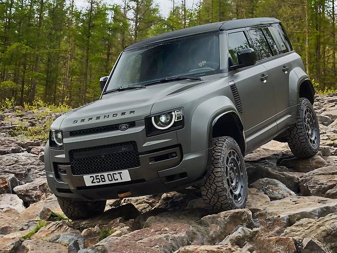 험난한 암석 지형을 통과하며 강력한 하체 성능을 보여주는 다크 그레이 랜드로버 디펜더 옥타의 오프로드 사진