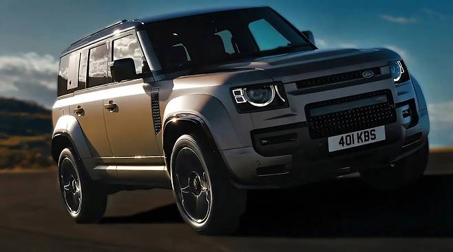 도로위를 역동적으로 주행하며 코너링하는 랜드로버 디펜더 옥타의 측면 사진