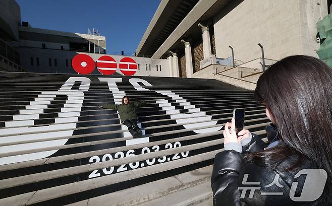 6일 오전 서울 종로구 세종문화회관 야외 계단에 설치된 BTS(방탄소년단)의 컴백 로고 조형물 앞에서 관광객들이 기념촬영을 하고 있다. BTS는 3월 20일 컴백과 새 앨범 발매, 월드투어 일정을 공식 발표했다. 2026.1.6/뉴스1 ⓒ News1 임세영 기자