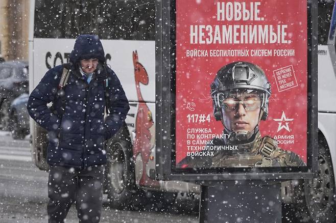 인도가 러시아 석유 구매를 중단하기로 했다는 도널드 트럼프 미국 대통령 발언의 진위가 다시 도마에 올랐다. 러시아 상트페테르부르크에서 4일(현지시간) 눈발이 흩날리는 가운데 한 시민이 군이 모집 광고판 앞을 지나고 있다. AP 뉴시스