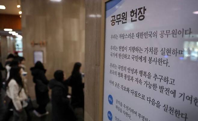 [서울=뉴시스] 배훈식 기자 = 지난해 2월 3일 오후 서울 종로구 정부서울청사 로비에 걸린 공무원 헌장 아래로 공무원들이 걸어가고 있다. 2025.02.03. dahora83@newsis.com *재판매 및 DB 금지